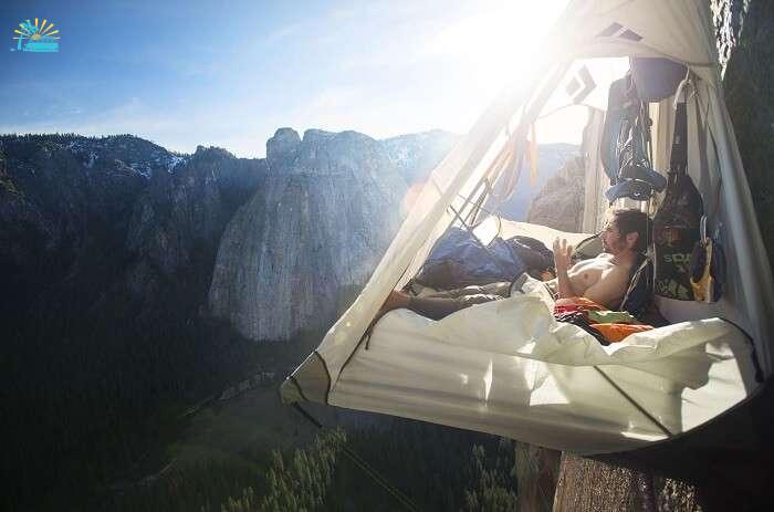 A man cliff camping on a mountain cliff