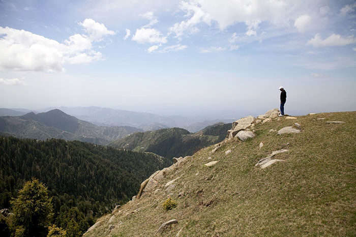 A man looking down from Dainkund Peak in Dalhousie