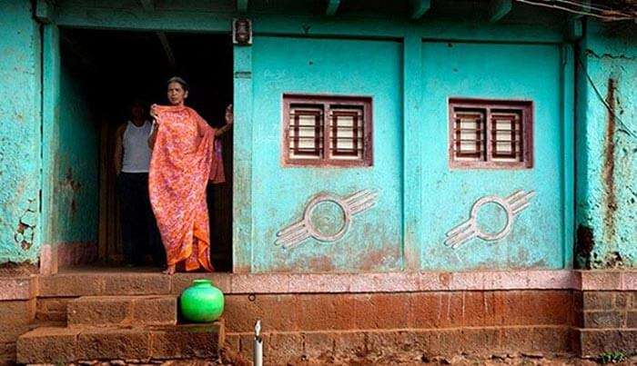 A woman looks outside her doorless house at Shani Shingnapur
