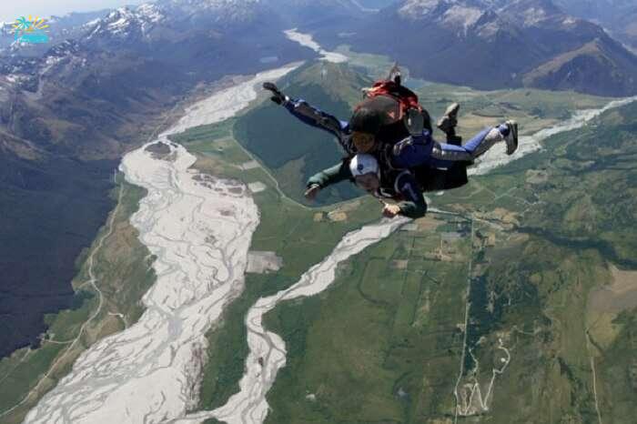 Adventurers skydiving in Glenorchy region in New Zealand