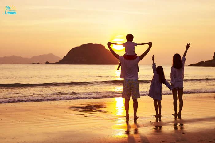 a family standing on a beach during sunset in hong kong