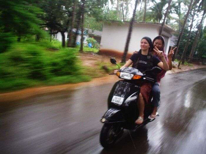 Girls enjoying a scooty ride in Goa in Monsoon