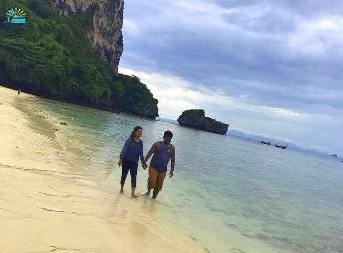 Jegen and his wife take a walk on a beach of Thailand