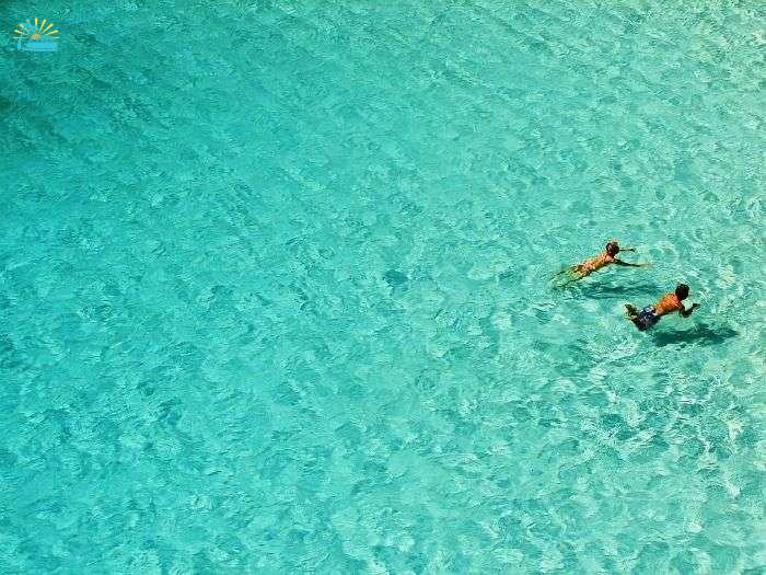 Swimmers in the turquoise Sea of Cala Macarelleta