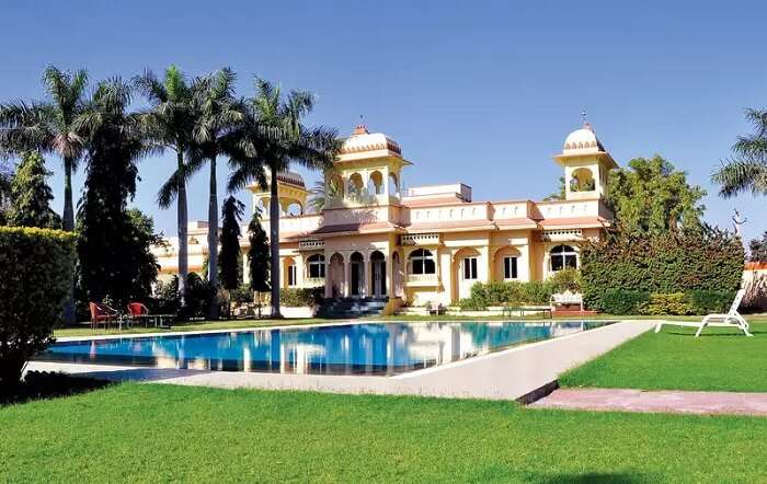 The sun-lit lawn and swimming pool at the Rajputana Resort