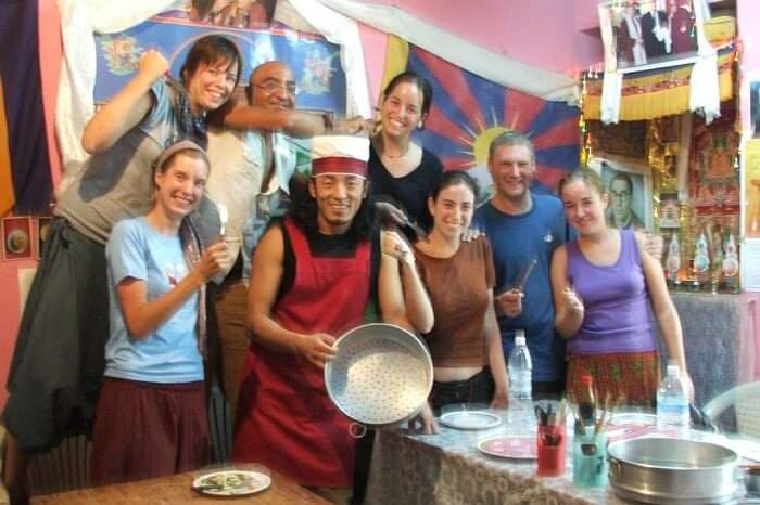 Tourists pose with the cook and trainer at the Sangey Kitchen