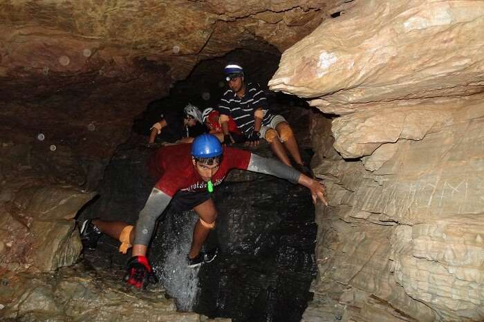 Tourists take a walk through the Budher Caves in Chakrata