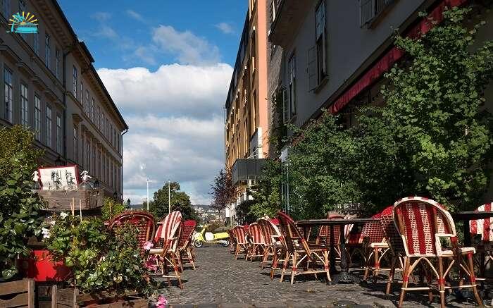 a cafe on street with red and white chairs